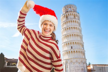 simsearch:400-08344334,k - Young, itching from energy and searching for excitement. I'm going to Christmas trip to Italy. It is a no-brainer. Portrait of laughing woman in Santa hat in front of Leaning Tour of Pisa. Stock Photo - Budget Royalty-Free & Subscription, Code: 400-08343847