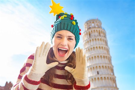 simsearch:400-08344334,k - Young, itching from energy and searching for excitement. I'm going to Christmas trip to Italy. It is a no-brainer. Happy woman in Christmas tree hat shouting in front of Leaning Tour of Pisa Stock Photo - Budget Royalty-Free & Subscription, Code: 400-08343864