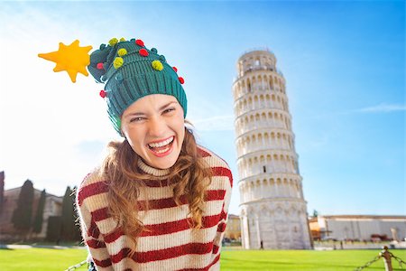 simsearch:400-08344334,k - Young, itching from energy and searching for excitement. I'm going to Christmas trip to Italy. It is a no-brainer. Portrait of merry young woman in Christmas tree hat in front of Leaning Tour of Pisa Stock Photo - Budget Royalty-Free & Subscription, Code: 400-08343869