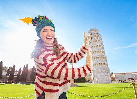 simsearch:400-08344334,k - Young, itching from energy and searching for excitement. I'm going to Christmas trip to Italy. It is a no-brainer. Smiling young woman in Christmas tree hat supporting Leaning Tour of Pisa Stock Photo - Budget Royalty-Free & Subscription, Code: 400-08343871