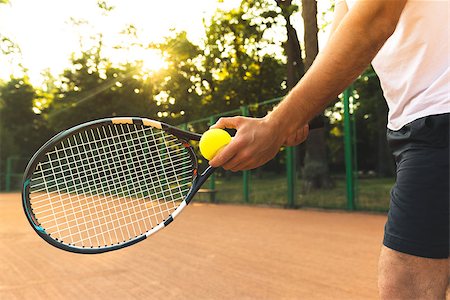 simsearch:400-08755898,k - Close up photo of young man on tennis court. Man playing tennis. Man is ready to throw tennis ball. Beautiful forest area as background Stock Photo - Budget Royalty-Free & Subscription, Code: 400-08374182