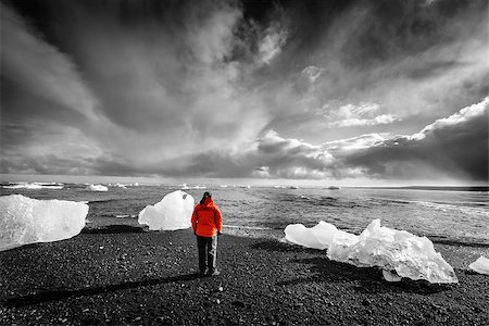 red rocks horizon - Tourist standing among ice pieces on a beach in southern Iceland. Selective color image Stock Photo - Budget Royalty-Free & Subscription, Code: 400-08374456