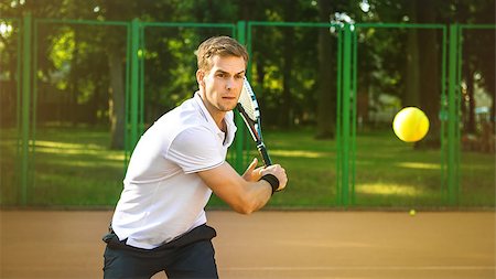 simsearch:400-08755898,k - Picture of handsome young man on tennis court. Man playing tennis. Man hitting tennis ball. Beautiful forest area as background Stock Photo - Budget Royalty-Free & Subscription, Code: 400-08374609