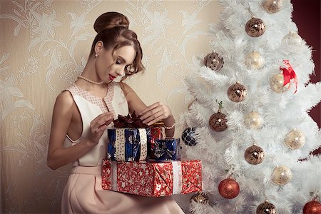 simsearch:400-06694116,k - elegant beautiful woman with hair-style sitting near decorated tree with some christmas presents. xmas concept. Photographie de stock - Aubaine LD & Abonnement, Code: 400-08374752