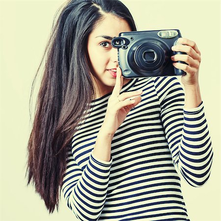 Girl wearing casual cloth posing with instant camera. Foto de stock - Super Valor sin royalties y Suscripción, Código: 400-08374776