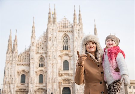 simsearch:400-08341864,k - Why not to hang out in Italian fashion capital Milan on winter holidays with family. Happy mother showing something to daughter while standing in front of Duomo Fotografie stock - Microstock e Abbonamento, Codice: 400-08379455