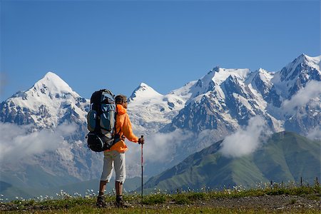 simsearch:877-08026622,k - Woman (backpacker)  with sunglasses and sticks contemplates mountains covered with snow. Tourist is situated on alpine meadow. Stock Photo - Budget Royalty-Free & Subscription, Code: 400-08371018