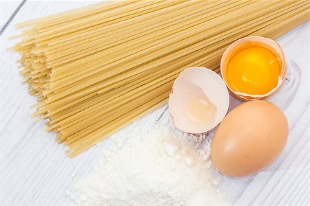 Uncooked spaghetti, flour and eggs on wooden table Stock Photo - Budget Royalty-Free & Subscription, Code: 400-08371298