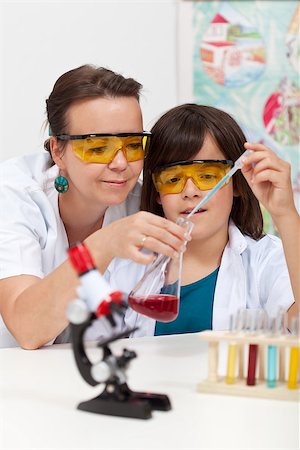 scientist and teacher photo - Chemistry experiment at school - boy mixing two chemicals helped by his teacher Stock Photo - Budget Royalty-Free & Subscription, Code: 400-08371770