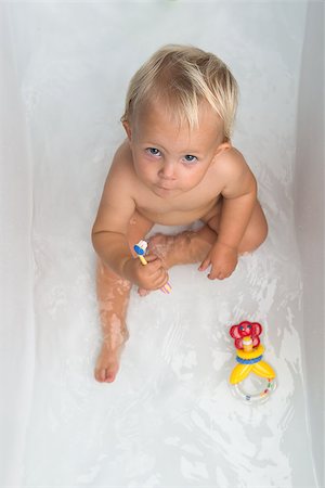 Baby sitting in water in a bath and playing with colourful balls. Close portrait. Photographie de stock - Aubaine LD & Abonnement, Code: 400-08373240