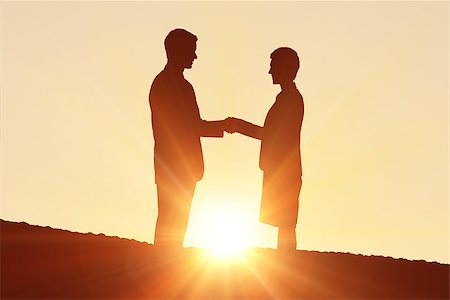 Silhouettes shaking hands against a sun set Stock Photo - Budget Royalty-Free & Subscription, Code: 400-08380198