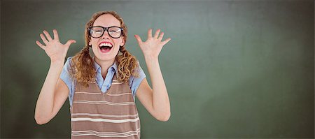 simsearch:400-08380794,k - Geeky hipster woman smiling and showing her hands  against green chalkboard Stockbilder - Microstock & Abonnement, Bildnummer: 400-08380626