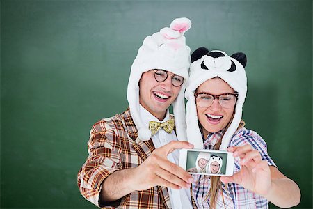simsearch:400-08380794,k - Geeky hipster couple taking selfie with smart phone  against green chalkboard Stockbilder - Microstock & Abonnement, Bildnummer: 400-08380649