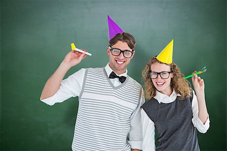 simsearch:400-08380794,k - Geeky couple with party hat and party horn against green chalkboard Stockbilder - Microstock & Abonnement, Bildnummer: 400-08380652