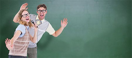 simsearch:400-08380794,k - Geeky hipster couple singing into a microphone against green chalkboard Stockbilder - Microstock & Abonnement, Bildnummer: 400-08380664