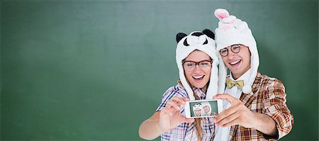 Geeky hipster couple taking selfie with smart phone  against green chalkboard Stock Photo - Budget Royalty-Free & Subscription, Code: 400-08380665