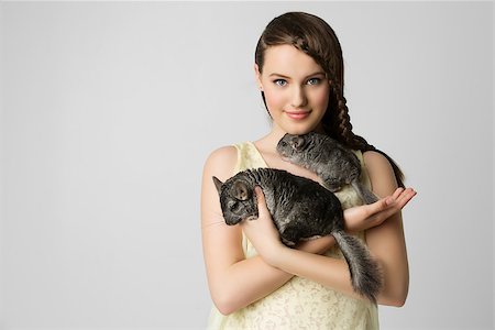 Beautiful teenage girl holding two pet chinchillas. Over light grey background. Stock Photo - Budget Royalty-Free & Subscription, Code: 400-08404407