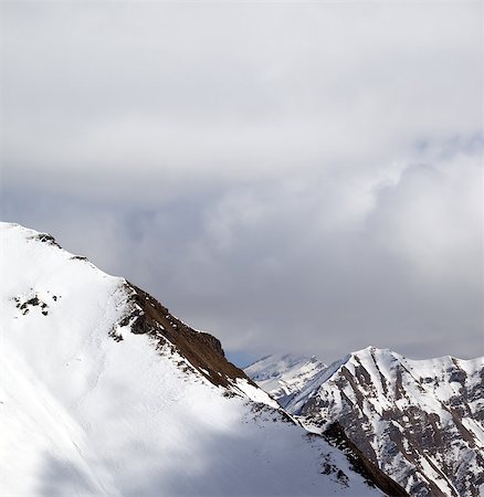 simsearch:400-08530488,k - Snowy slope and sky with clouds at sun day. Caucasus Mountains, Georgia. View from ski resort Gudauri. Stock Photo - Budget Royalty-Free & Subscription, Code: 400-08405612