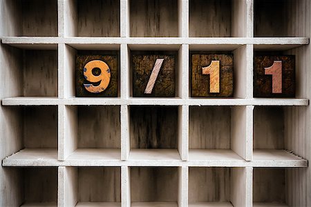 The word "9/11" written in vintage ink stained wooden letterpress type in a partitioned printer's drawer. Foto de stock - Royalty-Free Super Valor e Assinatura, Número: 400-08406128
