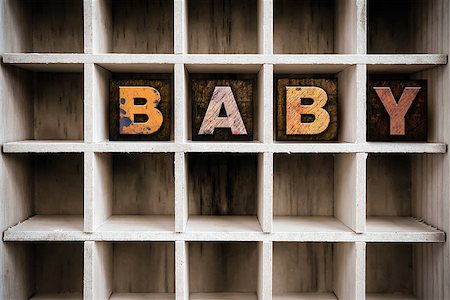 The word "BABY" written in vintage ink stained wooden letterpress type in a partitioned printer's drawer. Foto de stock - Super Valor sin royalties y Suscripción, Código: 400-08406139