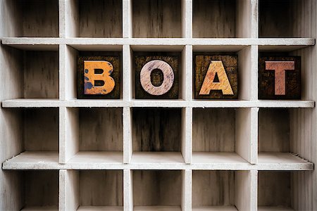 The word "BOAT" written in vintage ink stained wooden letterpress type in a partitioned printer's drawer. Stock Photo - Budget Royalty-Free & Subscription, Code: 400-08406147
