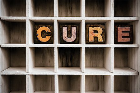 The word "CURE" written in vintage ink stained wooden letterpress type in a partitioned printer's drawer. Stockbilder - Microstock & Abonnement, Bildnummer: 400-08406988