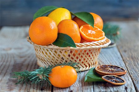 fruit winter basket - Tangerines and lemons with leaves in a wicker basket. Photographie de stock - Aubaine LD & Abonnement, Code: 400-08407423