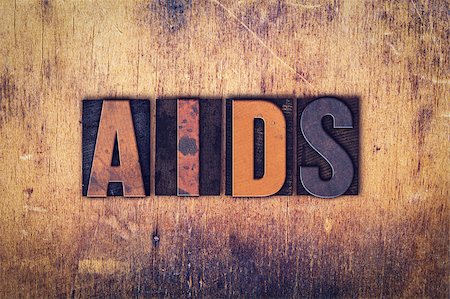 The word "AIDS" written in dirty vintage letterpress type on a aged wooden background. Photographie de stock - Aubaine LD & Abonnement, Code: 400-08409433
