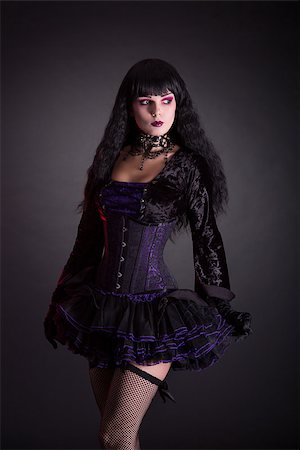 simsearch:400-07209173,k - Halloween witch in purple costume, studio shot on black background Fotografie stock - Microstock e Abbonamento, Codice: 400-08400057