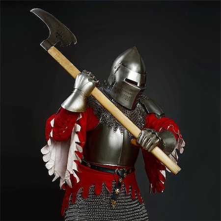 Powerful knight in the armor. Medieval knight in the field with an axe. Dark background. Stock Photo - Budget Royalty-Free & Subscription, Code: 400-08400195