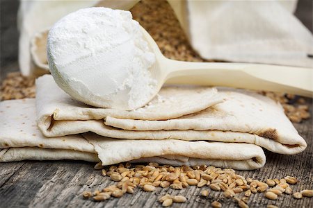 Pita bread with grains and flour on wooden table Foto de stock - Royalty-Free Super Valor e Assinatura, Número: 400-08400966