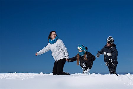 Winter fun in the deep snow - family enjoying the walk on a sunny winter day, with copy space Fotografie stock - Microstock e Abbonamento, Codice: 400-08401126