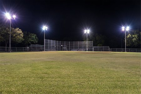 Night photo of an empty baseball field at night looking back toward home plate from right field with the lights on and contrasting against the blackness of the night sky. Stock Photo - Budget Royalty-Free & Subscription, Code: 400-08401227