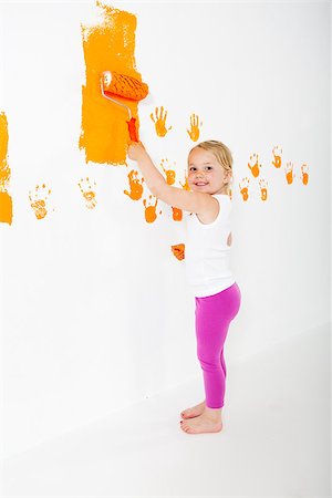 Little girl painting white wall with orange color Stock Photo - Budget Royalty-Free & Subscription, Code: 400-08401602