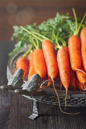 simsearch:6113-08985950,k - Fresh organic kitchen garden carrots on vintage plate close-up. Toned photo. Photographie de stock - Aubaine LD & Abonnement, Code: 400-08402603