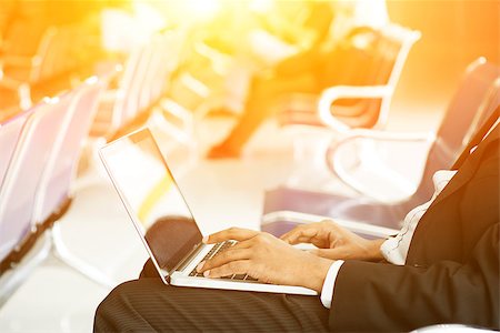 Business man using laptop while waiting his flight at airport, beautiful golden sunlight background. Stock Photo - Budget Royalty-Free & Subscription, Code: 400-08402621