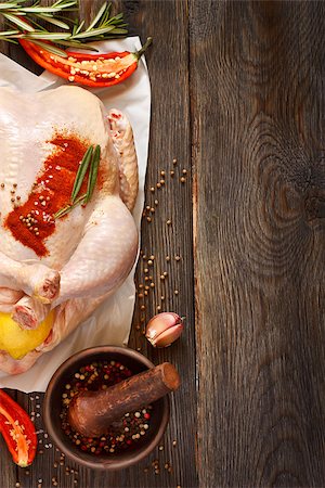 Fresh raw whole chicken stuffed lemon and spices for cooking on wooden board. Top view. Stock Photo - Budget Royalty-Free & Subscription, Code: 400-08402729