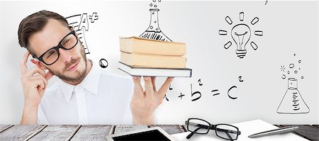 simsearch:400-07682840,k - Geeky young man looking at pile of books against desk Fotografie stock - Microstock e Abbonamento, Codice: 400-08414158