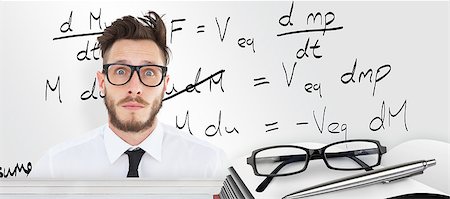 simsearch:400-07682840,k - Geeky young businessman looking at camera against desk Fotografie stock - Microstock e Abbonamento, Codice: 400-08414159