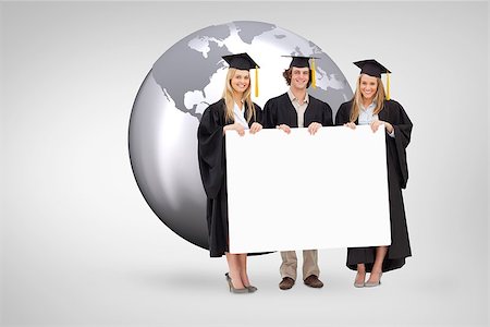 Three students in graduate robe holding a blank sign against grey vignette Stock Photo - Budget Royalty-Free & Subscription, Code: 400-08414396