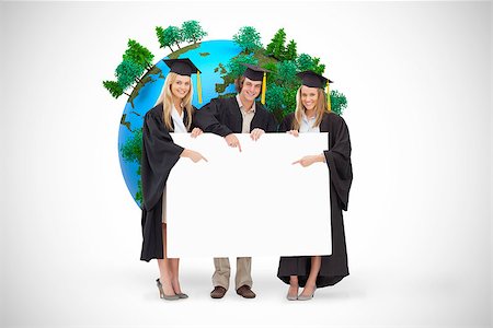 Three students in graduate robe holding and pointing a blank sign against white background with vignette Stock Photo - Budget Royalty-Free & Subscription, Code: 400-08414399