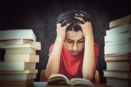 Tensed boy sitting with stack of books against black Stock Photo - Budget Royalty-Free & Subscription, Code: 400-08414434