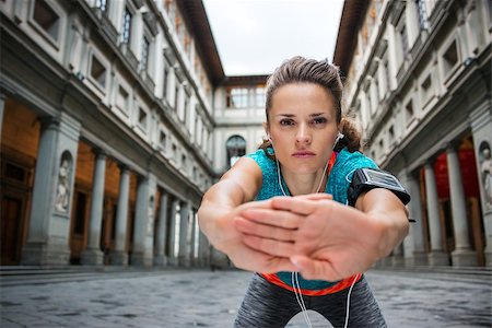 simsearch:400-08022064,k - Now it is time to invest in your body and no matter you are at hometown or traveling. Sportswoman with headset is stretching next to Uffizi gallery in Florence Italy Photographie de stock - Aubaine LD & Abonnement, Code: 400-08414768
