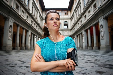 simsearch:400-08022064,k - Now it is time to invest in your body and no matter you are at hometown or traveling. Fitness young woman with headset is staying in front of Uffizi gallery and listening music Photographie de stock - Aubaine LD & Abonnement, Code: 400-08414774