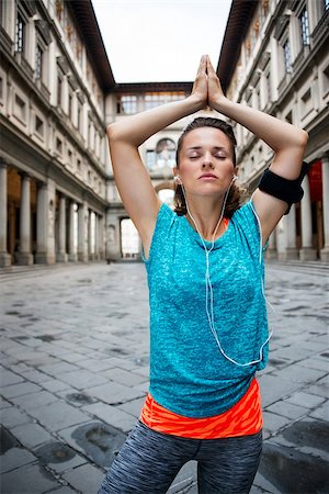 simsearch:400-08022064,k - Now it is time to invest in your body and no matter you are at hometown or traveling. Fitness young woman with earphones doing yoga outdoors in front of Uffizi gallery in Florence Italy Photographie de stock - Aubaine LD & Abonnement, Code: 400-08414772