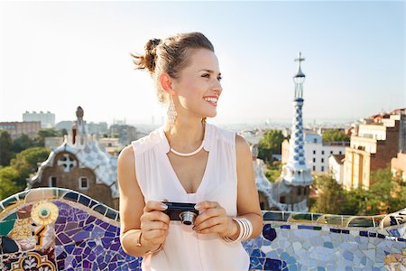 simsearch:400-08415527,k - Refreshing promenade in unique Park Guell style in Barcelona, Spain. Happy young woman tourist holding digital photo camera and looking aside while in Park Guell, Barcelona, Spain Stock Photo - Budget Royalty-Free & Subscription, Code: 400-08415534