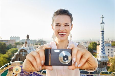 simsearch:400-08415527,k - Refreshing promenade in unique Park Guell style in Barcelona, Spain. Smiling young woman tourist taking photo with digital photo camera while standing in Park Guell, Barcelona, Spain Stock Photo - Budget Royalty-Free & Subscription, Code: 400-08415535