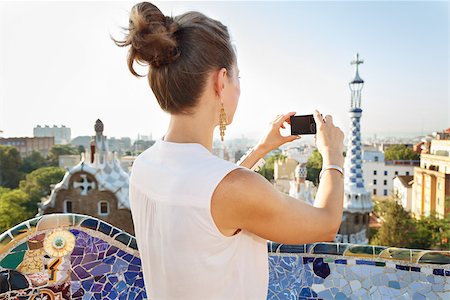 simsearch:400-08415527,k - Refreshing promenade in unique Park Guell style in Barcelona, Spain. Seen from behind young woman tourist taking photo with digital photo camera while standing in Park Guell, Barcelona, Spain Stock Photo - Budget Royalty-Free & Subscription, Code: 400-08415537