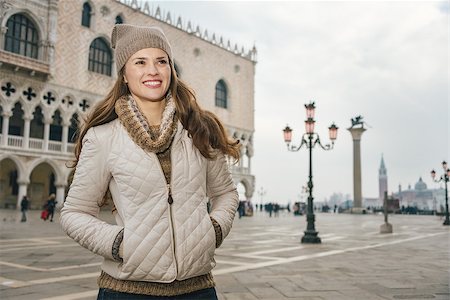 simsearch:400-08344334,k - Delightful Venice, Italy can help make the most of your next winter getaway. Smiling young woman tourist standing on St. Mark's Square near Dogi Palace and looking into the distance Stock Photo - Budget Royalty-Free & Subscription, Code: 400-08415684