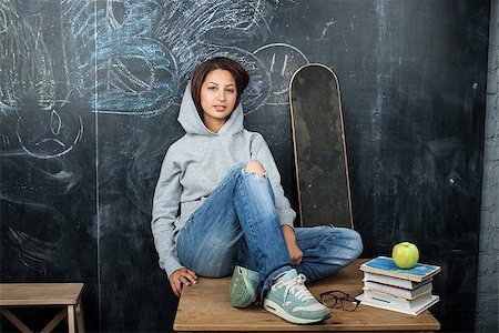 young cute teenage girl in classroom at blackboard seating on table smiling close up Stock Photo - Budget Royalty-Free & Subscription, Code: 400-08413431